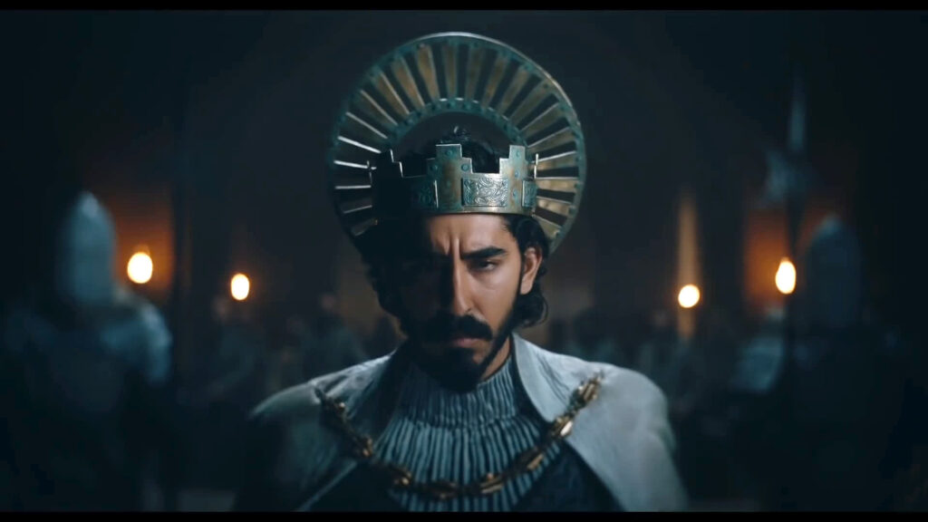 Still from The Green Knight of Dev Patel wearing a crown and chainlink armour