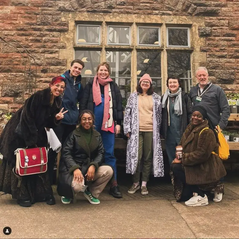 A diverse group of young people stood smiling in front of Tyntesfield’s Cow Barn following their delivery. Photo by Rising Arts Agency.